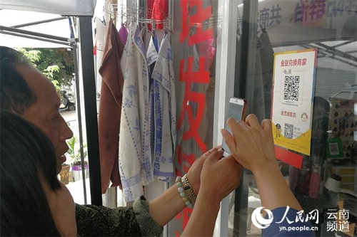 社区居民扫二维码消费金豆。（人民网 李发兴 摄）